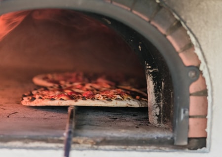 Cuisson de la pizza sur pierre au four à bois